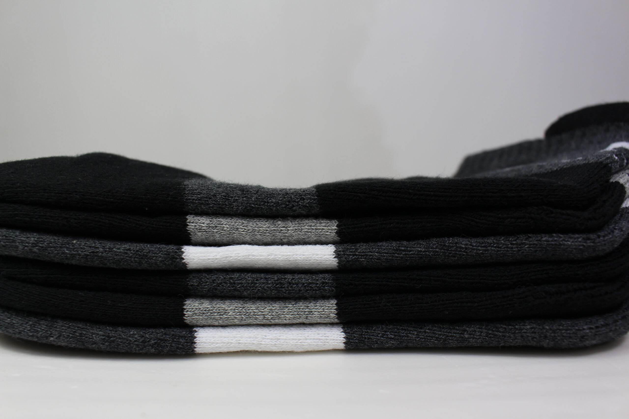 Stack of badminton crew socks with terry-loop sole visible at the edge